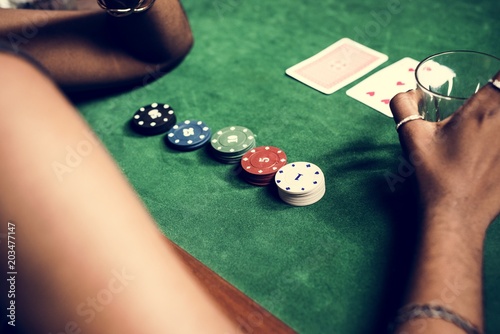 фотография Closeup of hands with gambling tokens and card