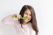 © kaganskaya115 - Little cute child girl brushing her teeth on white background. Space for text. Healthy teeth.