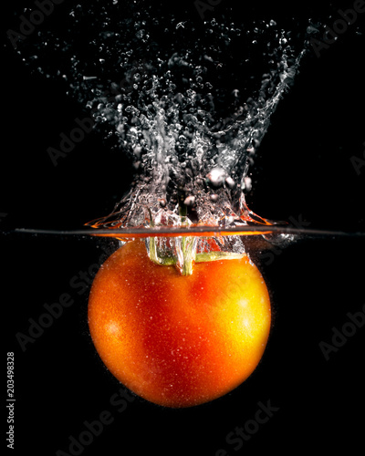 czerwony-pomidor-w-wodzie-na-czarnym-tle