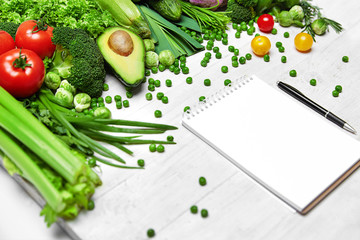 Wall Mural - Shopping List. Green Vegetables And Notebook On Table