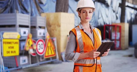 Wall Mural - Confident woman contractor posing confidently with tablet on construction site