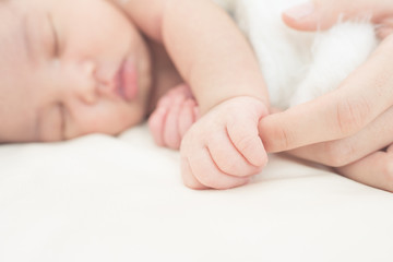 Wall Mural - hand of a newborn baby in the hand of a parent dad