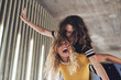 © Flamingo Images - Laughing young woman carrying a girlfriend on her shoulders