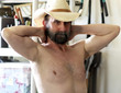 A Bearded Cowboy Rubbing His Aching Neck in His Tool Shed