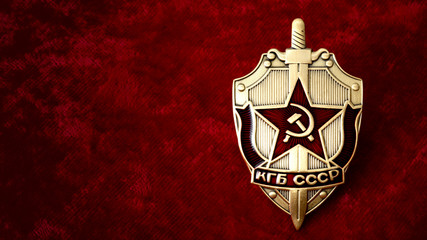 Secret service, intelligence agency, and espionage concept with cold war era KGB badge from the former USSR, on red background with copy space