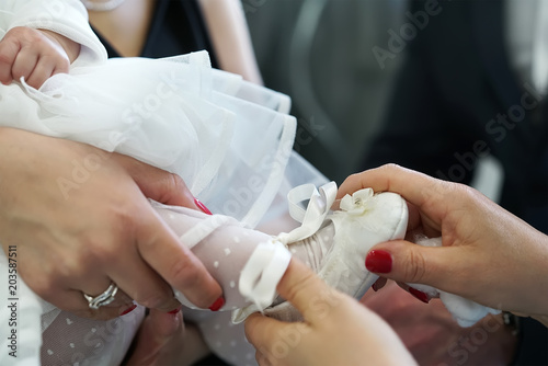 Fotomural put on baby booties for baptism