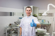 © Yuliia - Male dentist standing over medical office background. Healthcare, profession, stomatology and medicine concept