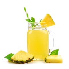 Pineapple juice in a mason jar glass with fruit, mint and straw isolated on a white background