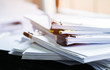 Stack of papers documents in archives files with clip papers on table at offices,  Busy offices and Pile of data unfinished folders on office desk indoor near window,  Business concept.