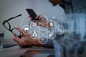 Poster - Businessman hand using mobile payments online shopping,pencil,omni channel,laptop computer on wooden desk in modern office,filter effect