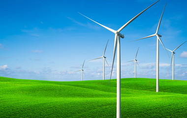 Wind turbines farm on a green grass hills.