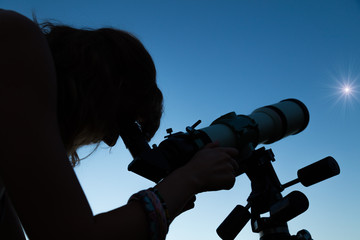 Wall Mural - woman looking at the stars with a telescope.