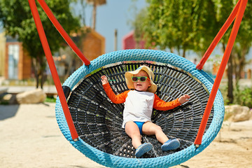 Wall Mural - Toddler child swinging on beach