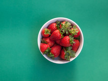 Top View Of Strawberries On Plain Green Background