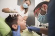 © qunica.com - Teenager having his tooth removed at the dentist office - oral hygiene health care concept