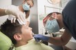 © qunica.com - A boy having his tooth removed is being comforted by a nurse at the dentist office - oral hygiene health care concept