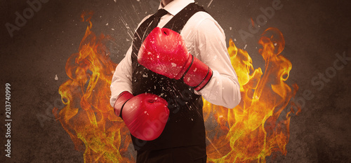 Obraz Dibond A strong sales person breaking something into pieces with red boxing gloves concept illustrated with glowing residue flying in the air.