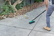 Man sweeping the driveway with a broom