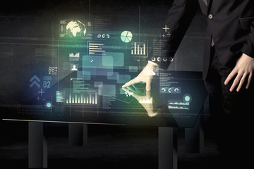 Poster - Businessman touching interactive modern desk with technology icons on table