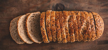 Top View Of Sliced Wholegrain Bread On Dark Ructic Wooden  Background Closeup.