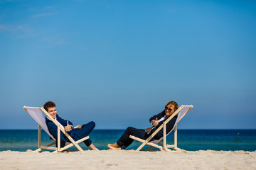 Wall Mural - Woman and man relaxing on beach