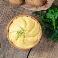 Wall Mural - Mashed potatoes, boiled puree in brown bowl on dark wooden rustic background, top view