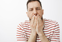 Guy Drink Lots Of Alcohol, Feeling Hangover And Stomach Disorder. Portrait Of Sick Funny Guy In Casual Clothes, Covering Mouth With Palms, Feeling Dizzy And Wanting Vomit Or Puke Over Gray Wall