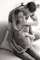 Poster - Young pregnant woman with husband at home, black and white effect