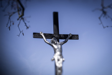 Jesus on cross under tree against blue sky, Christianity symbol abstract background, Old memorial cross, Religious Christian symbol