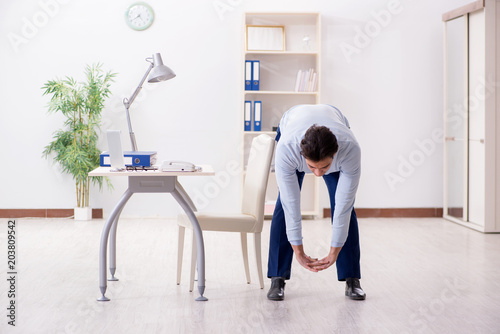 Fotografie, Obraz Employee doing stretching exercises in the office
