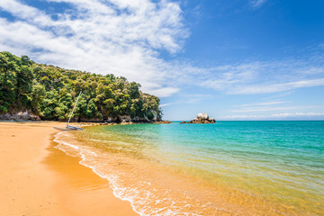 Abel Tasman National Park, New Zealand: Magical sandy beach with turquoise blue water on beautiful sunny summer day, enjoy breathtaking landscape by exploring the Splitt Apple ocean coast by kayaking