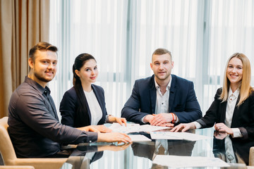 Wall Mural - happy successful team of confident business men and women sitting in a board room. corporate people professional lifestyle. company executives workspace