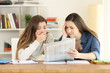 © Antonioguillem - Two worried students reading a newspaper