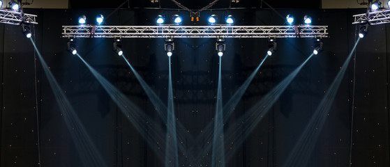 Luminous rays from concert lighting against a dark background, musical instrument concept