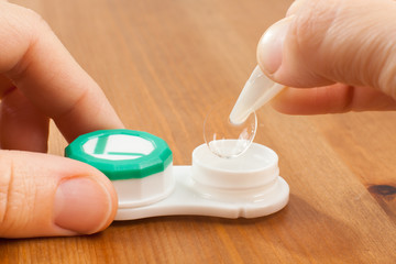 Sticker - hands taking out the contact lens from the container