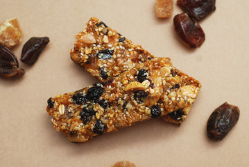 Granola Bars on Craft Paper Background with Cereal Nuts and Dried Fruits. diet, Fitness and Healthy Food Concept.