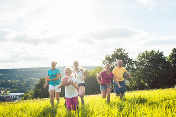 Wall Mural - Family playing, running and doing sport in summer landscape