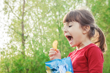 child eats chips. selective focus.  