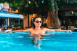 © bedya - Pretty brunette girl relaxing at the swimming pool