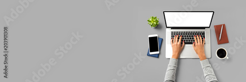Cuadros en Lienzo Overhead shot of office desktop with female hands working on modern laptop