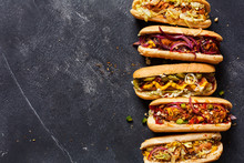 Hot Dogs With Different Toppings On A Dark Background.