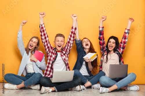 Fotografía Group of young cheerful school friends doing homework