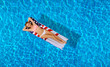 © Dmytro Flisak - Woman in bikini on the inflatable mattress in the swimming pool.