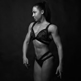 Fototapeta  - Muscular girl on a black background. Sport, fitness model.