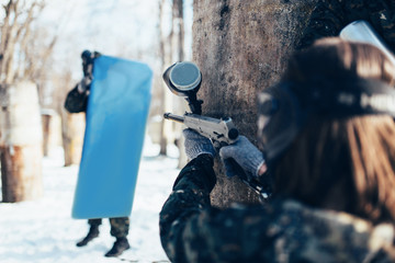 Wall Mural - Paintball player shooting at enemy with the shield