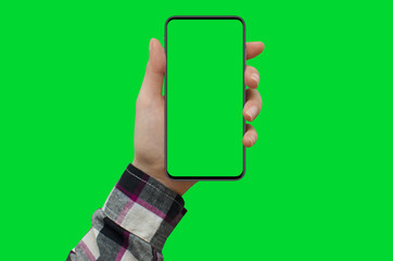 Wall Mural - Woman's hand shows smartphone with green screen in vertical position, green background.