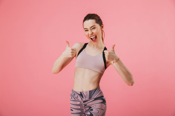 Canvas Print - Cheerful sportswoman showing thumbs up and looking at the camera