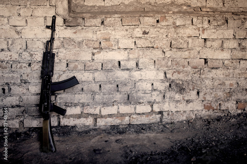 Fotomural submachine gun kalashnikov AK-47 against the wall