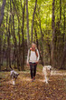 © IoaBal - Young woman walks along with dogs in the woods