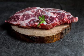 Fresh pork on a wooden board, dark background